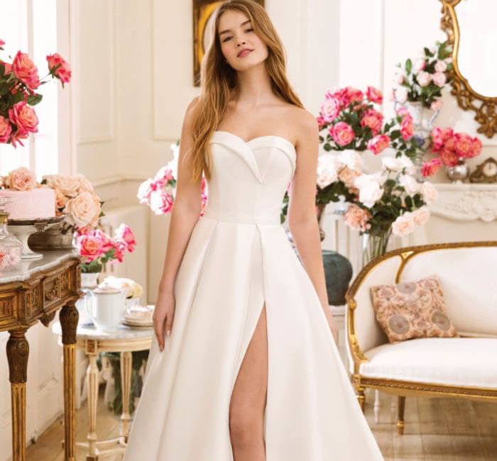 Model wearing a white gown by BE Collection